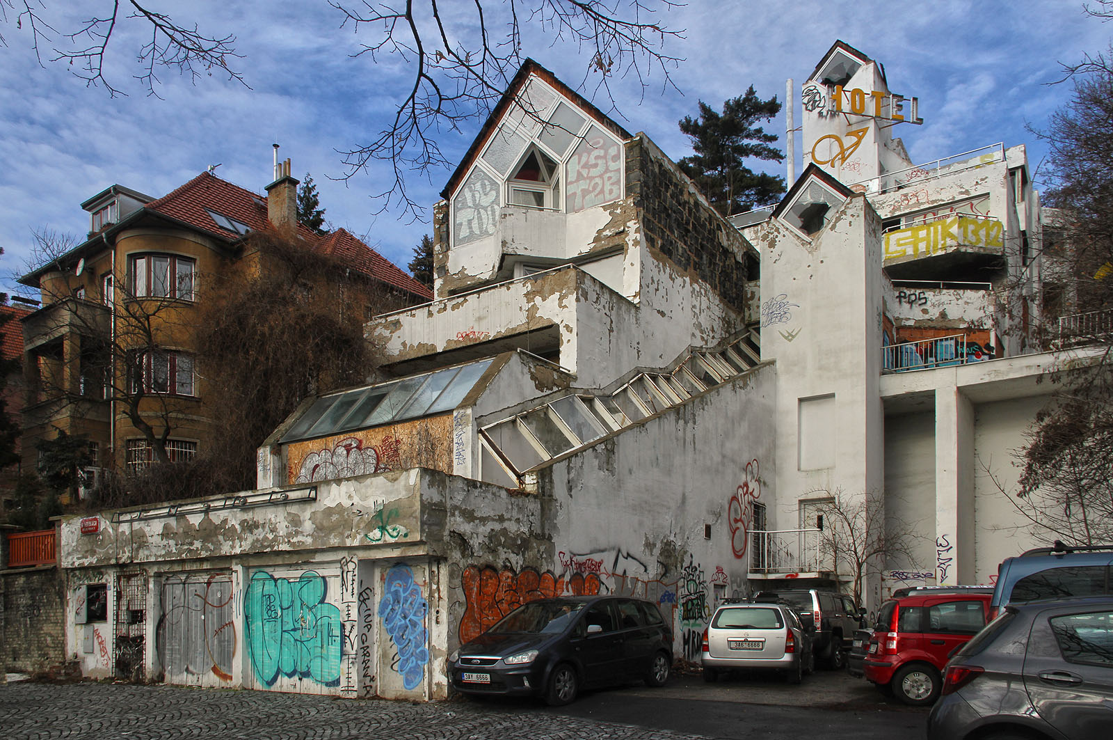 Kaskádovitý hotel potřeboval dva výtahy, protože žádná šachta nemohla procházet všemi patry. Prostor před dolním výtahem si oblíbili obyvatelé okolních domů, kteří si z něj udělali divoké parkoviště. Kaskádovitý hotel potřeboval dva výtahy, protože žádná šachta nemohla procházet všemi patry. Prostor před dolním výtahem si oblíbili obyvatelé okolních domů, kteří si z něj udělali divoké parkoviště.