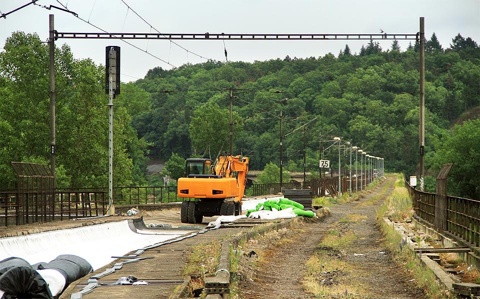 Bagr hlídá místo, kde se z Mostu intelignce měla oddělit jednokolejná spojka povádějící vlaky tunelem do Prokopského údolí, resp. později až do Berouna. Starší varianta je na plánku označená jako Hlubočepská spojka, novější pak jako spojka Žvahovská. Nejnovější tunel jako Tunel do Berouna. Bagr hlídá místo, kde se z Mostu intelignce měla oddělit jednokolejná spojka povádějící vlaky tunelem do Prokopského údolí, resp. později až do Berouna. Starší varianta je na plánku označená jako Hlubočepská spojka, novější pak jako spojka Žvahovská. Nejnovější tunel jako Tunel do Berouna.