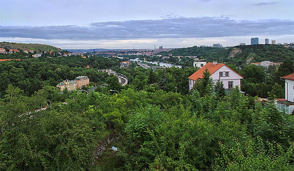 Pohled z okna vily směrem na severovýchod - k centru města na Vltavu a věž pustnoucích Barrandovských teras (za červenou střechou domu v popředí). Pohled z okna vily směrem na severovýchod - k centru města na Vltavu a věž pustnoucích Barrandovských teras (za červenou střechou domu v popředí).