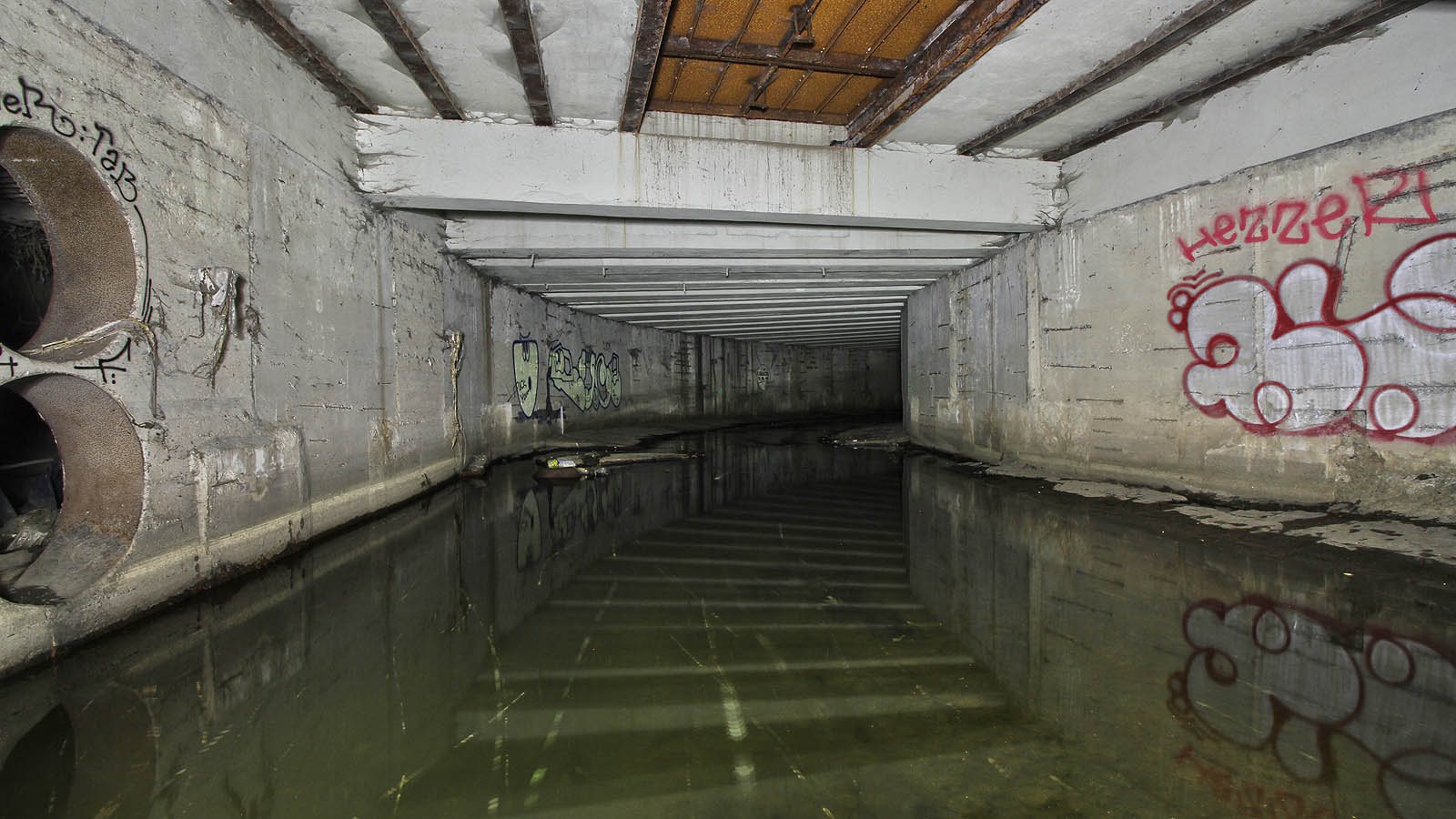 Pohled na nejvyšší část tunelu Botiče, zpod železniční trati. Vlevo je vidět ocelové průchodky spojující tunel se systémem dešťové kanalizace. Pohled na nejvyšší část tunelu Botiče, zpod železniční trati. Vlevo je vidět ocelové průchodky spojující tunel se systémem dešťové kanalizace.